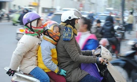 Phụ huynh chở con đi học giữa trời rét