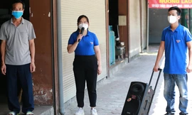 Cán bộ đoàn đến vận động mời bảo vệ nhà hàng đi xét nghiệm, tiêm vắc xin. Ảnh: .N.L