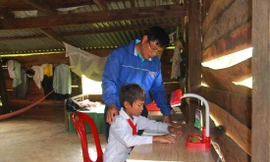 Thầy Mai Văn Chuyền, Chủ nhiệm CLB "Vì đàn em thân yêu" trao tặng bộ bàn học và động viên học sinh