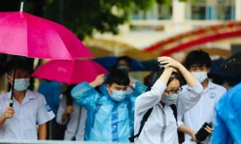 Thí sinh đội mưa đến điểm thi ở Hà Nội ngày 13/6. Ảnh: Như Ý 