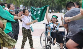 Dù ngồi xe lăn, chị Đặng Thị Bé vẫn lắc lư theo những giai điệu sôi động Ảnh: Giang Thanh