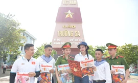 Hoa hậu Đỗ Thị Hà (thứ 4 từ trái qua) cùng các chiến sĩ ở đảo Trường Sa đọc báo Tiền Phong Ảnh: Dương Triều