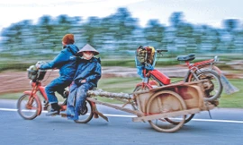 Một cặp vợ chồng ở ngoại thành Hà Nội đang trên đường về nhà sau khi chở hàng vào nội thành. Để tiết kiệm xăng, người chồng chở cả vợ và xe của vợ ở phía sau