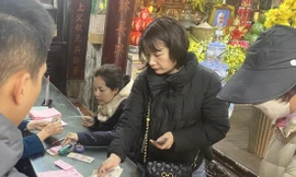 Người dân đóng tiền để đăng ký làm lễ cầu an, dâng sao giải hạn tại chùa Phúc Khánh (Thịnh Quang, Đống Đa, Hà Nội) Ảnh: VIỆT KHÔI