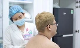 Bác sĩ thăm khám cho nam bệnh nhân mắc bệnh da liễu ảnh: Lan Anh 