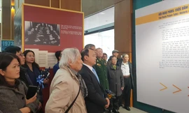 Các đại biểu xem và nghe thuyết minh tại Triển lãm “Hội nghị Paris - Cuộc đàm phán lịch sử” Ảnh: KIẾN NGHĨA