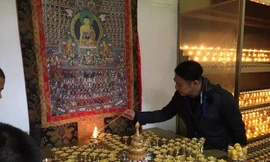 Anh thắp nến cầu nguyện. Ảnh: Phượng Hoàng.