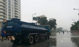 Nhiều người đi đường tỏ ra bất ngờ khi chứng kiến hình ảnh xe bồn chở nước rửa đường giữa trời mưa.