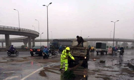 Lực lượng CSGT xúc cát rải lên vết dầu loang trên đường.