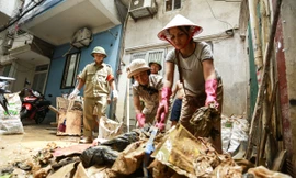 Người dân ven sông Hồng dọn dẹp nhà cửa khi nước rút