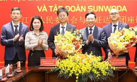 Chủ tịch UBND tỉnh Bắc Giang Lê Ánh Dương (ở giữa) tặng hoa chúc mừng Tập đoàn Sunwoda (bên trái) và chủ đầu tư hạ tầng KCN Yên Lư ký kết hợp đồng nguyên tắc đầu.