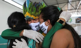 Anh Miqueias Moreira Kokama, con trai tù trưởng Messias Kokama, ôm người thân trong đám tang bố ở thành phố Manaus của Brazil hôm 14/5. Tù trưởng qua đời ở tuổi 53. Ảnh: Reuters.