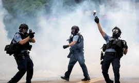 Cảnh sát ném lựu đạn cay về phía người biểu tình ở thành phố Minneapolis (Mỹ) ngày 26/5. Ảnh: AP.