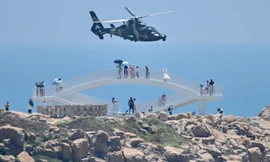 Du khách ngày 4/8 nhìn trực thăng quân sự của Trung Quốc bay qua đảo Pingtan, một trong những điểm của Trung Quốc đại lục gần Đài Loan nhất. Ảnh: Getty Images.