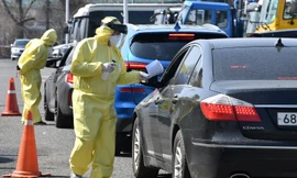 Nhân viên y tế Hàn Quốc hướng dẫn tài xế có triệu chứng mắc Covid-19 tại một điểm lái xe qua ở thành phố Goyang phía bắc thủ đô Seoul. Ảnh: Getty.