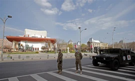 Binh sĩ đeo khẩu trang đứng gác trên đường phố thủ đô Bucharest của Romania ngày 28/3. Ảnh: Xinhua.