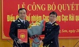 Ông Nguyễn Hồng Linh (bìa trái) nhận Quyết định và hoa chúc mừng của lãnh đạo Tổng cục Hải quan -Ảnh: Duy Chiến 