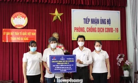 Nhà báo Trần Tuấn, Trưởng đại diện Báo Tiền Phong miền Trung trao tặng Ủy ban Mặt trận Tổ quốc Việt Nam TP Đà Nẵng 1400 bộ đồ bảo hộ, 650 phần quà cho con em các y bác sĩ lực lượng tuyến đầu chống dịch. Ảnh: Giang Thanh