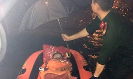 Công an quận Thanh Khê giải cứu 1 phụ nữ mang thai cùng hai con nhỏ ra khỏi khu vực ngập sâu. Ảnh: CACC