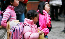 Học sinh tiểu học ở nhiều thành phố lớn phải mang cặp sách nặng. Ảnh: Hồng Vĩnh