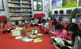 Học sinh Trường Tiểu học Pả Vi đọc sách báo được trao tặng trong khi trường bị phong tỏa
