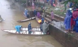 Lực lượng chức năng và người dân tìm kiếm tung tích nam thanh niên lao cả người và xe xuống sông.