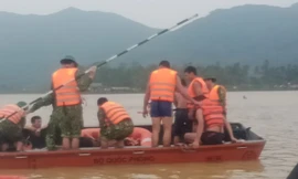 Lực lượng chức năng tìm vớt thi thể em Phúc trên cánh đồng nước lũ vẫn dâng cao. Ảnh: Báo Nghệ an 