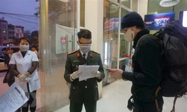 Du khách người nước ngoài phải đối chiếu tờ khai y tế với hộ chiếu khi xuống tàu ở Ga Lào Cai. (Ảnh: Quốc Khánh/TTXVN)