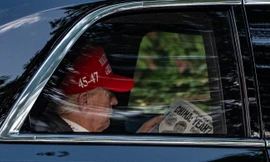 Tổng thống Donald Trump đọc báo khi trên đường đến Câu lạc bộ Golf quốc gia Trump ngày 5/4. (Ảnh: AP)