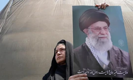 Một người dân giương cao ảnh chân dung Đại giáo chủ Iran trong cuộc biểu tình tại Tehran ngày 13/6. (Ảnh: AP)