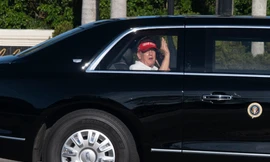 Tổng thống Mỹ Donald Trump vẫy tay khi đang ngồi trên chiếc limousine trở về khu biệt thự và sân golf của ông ở West Palm Beach ngày 8/3. (Ảnh: AP)