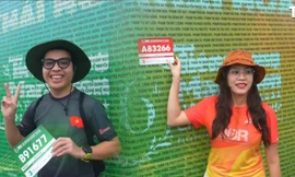 Runner háo hức check-in bảng tên dưới mưa, sẵn sàng chinh phục Tiền Phong Marathon 2025