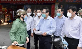 Thủ tướng Phạm Minh Chính xem giấy tờ của người tham gia giao thông tại quận Thanh Xuân, Hà Nội chiều 31/8 Ảnh: Nhật Minh 