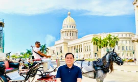 Tác giả trên nền một chiếc xe cổ đi ngang qua toà nhà Capitolio nổi tiếng ở La Habana Ảnh: Minh Vũ