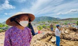 Bà Nguyễn Thị Cúc giữa ngổn ngang sạt lở ở nghĩa trang Hòa Sơn. Ảnh: Nguyễn Thành