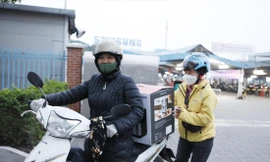 Chị Nguyễn Thị Mười phấn khởi có “cuốc” xe ôm chở một nữ công nhân sau giờ tan ca làm việc ảnh: Nguyễn thắng