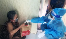 Nhân viên y tế phát túi thuốc cho F0 thực hiện cách ly, điều trị tại nhà