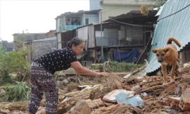 Bà Đỗ Thị Thanh Hoa (thôn Thạch Nham Đông) lật đống gạch vụn để tìm kiếm đồ đạc Ảnh: Giang Thanh 