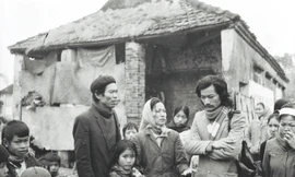 Nhà báo Mạnh Việt (tóc dài, quàng khăn) trong một lần tác nghiệp tại địa phương Ảnh: Phạm yên