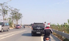 Nam thanh niên đu bám bên hông chiếc xe hạng sang. Ảnh cắt từ clip.