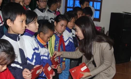 Hoa hậu Đỗ Mỹ Linh trao quà cho các em học sinh nghèo.