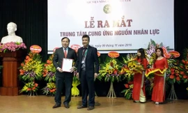 Ông Phạm Văn Cường, Phó giám đốc Học viện trao quyết định bổ nhiệm giám đốc trung tâm cho ông Vũ Ngọc Huyên (người cầm quyết định)