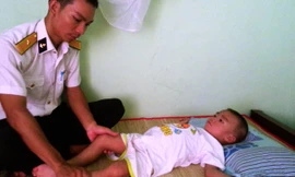 Thiếu úy Đinh Văn Đồng và cháu Quân. ảnh: TC