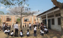 Các em học sinh Trường tiểu học Trần Quốc Toản vui chơi trên công trường đầy cát đá