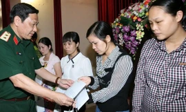 Trung tướng Nguyễn Hùng Mạnh, Chính ủy Bộ Tư lệnh Thủ đô, trao tiền hỗ trợ các gia đình. Ảnh: Trọng Đức/TTXVN