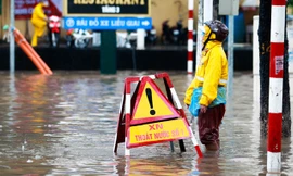 Công nhân thoát nước đội mưa giúp người đi đường. Ảnh TT0