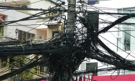 Lưới điện hạ thế và cáp viễn thông câu mắc chằng chịt tại giao lộ Hai Bà Trưng - Điện Biên Phủ. Ảnh: LT 