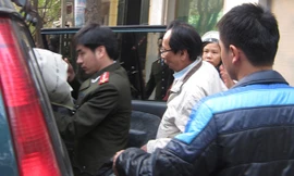 Ông Hồ Văn Hải (áo trắng) bị áp giải về cơ quan điều tra