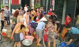 Người dân tại ngõ 362-364 phố Định Công đang mang xô chậu ra để nhận nước sạch từ xe chở nước (Ảnh chụp sáng ngày 23/5). Ảnh: Như Ý - Xuân Phú 