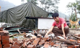 Anh Tạ Hồng Thanh bên ngôi nhà chỉ còn lại là đống đổ nát. Ảnh: Nguyễn Thành